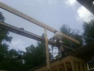 Carpenter setting a ridge beam over a new addition frame — Ice Dam Removal by Roofing Brothers in Ellisville