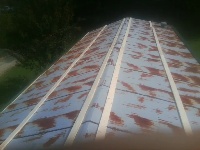 Rusted metal roof panels with new wood purlins before replacement — Storm Damage Roof Repair in Ellisville by Roofing Brothers