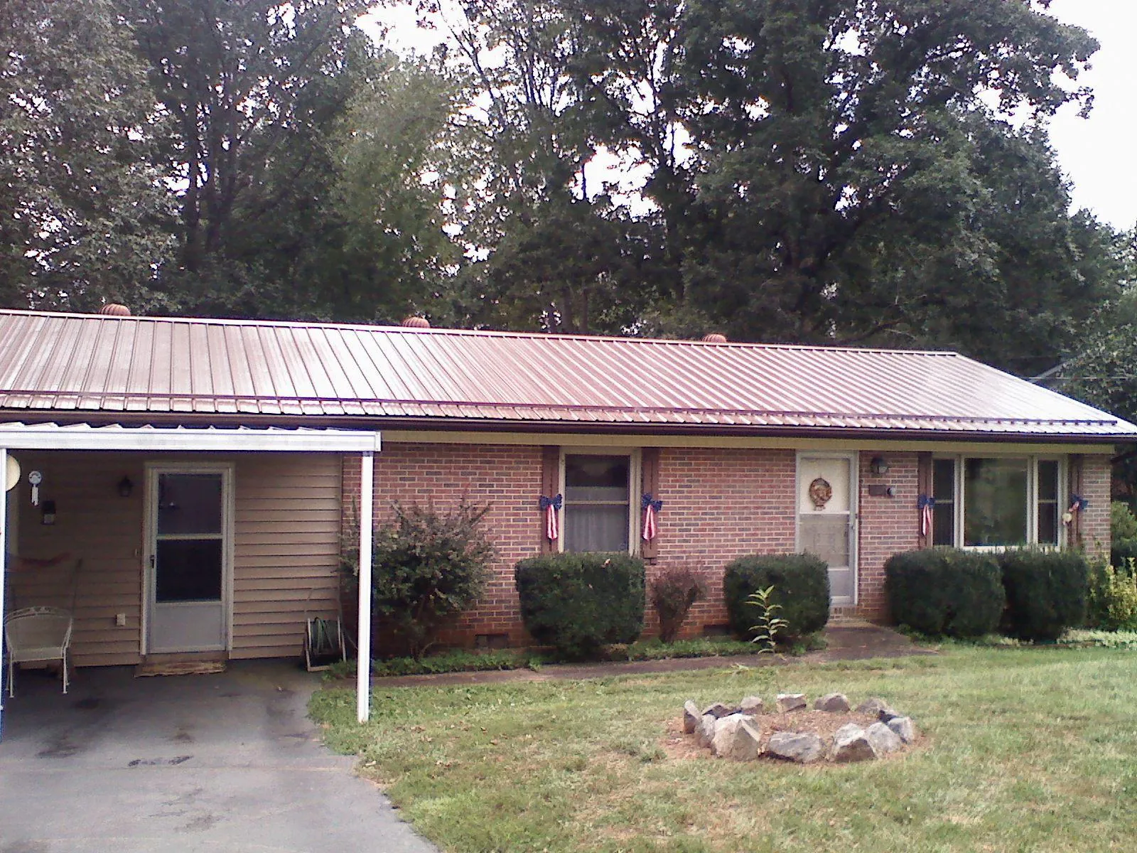 Bronze metal roof and carport on a brick ranch home — Roof Repair work by our crew in Ellisville